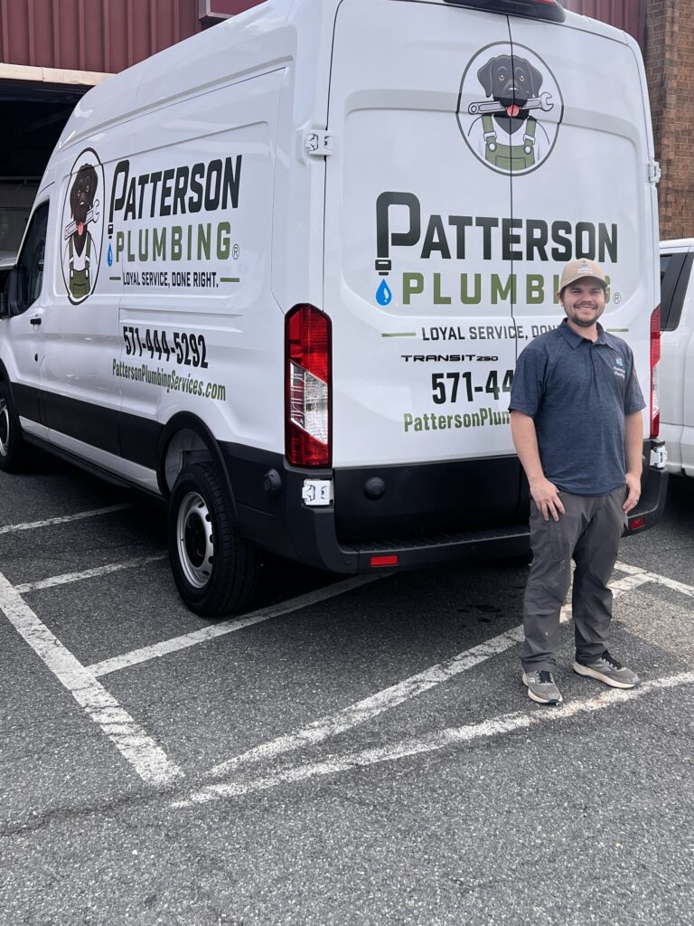 John Patterson, licensed Master Plumber and co-owner of Patterson Plumbing Services, standing in front of a company service van in Alexandria, VA